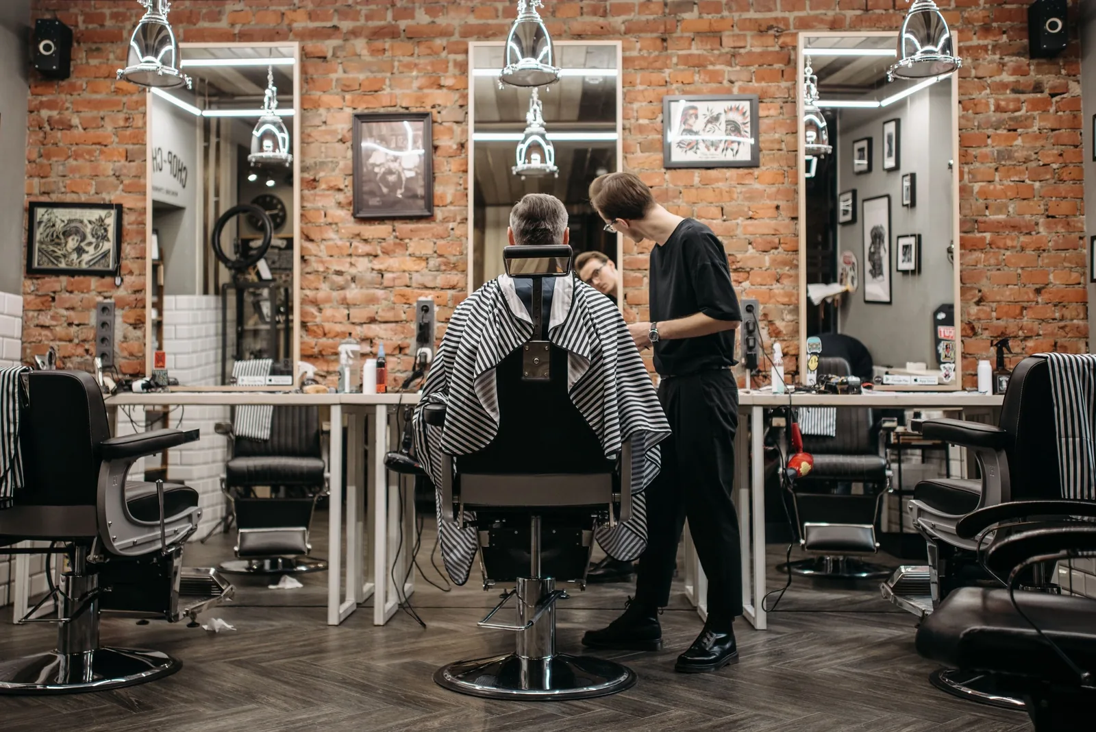 Inside Pomade: four barber chairs, mirrors and a brick wall