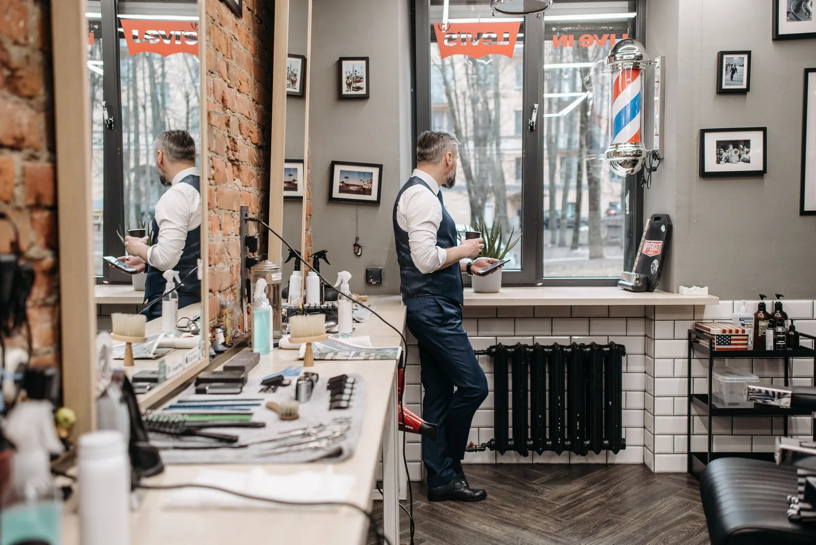 The shop floor at Pomade: barber chairs, mirrors and a brick wall